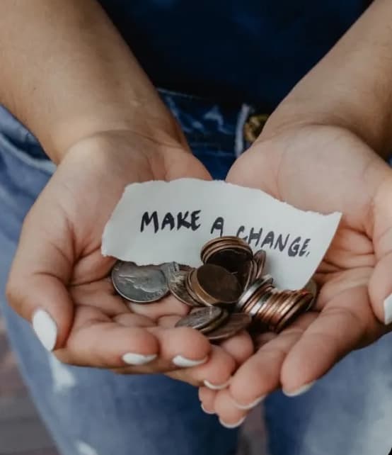 Hands holding coins with a message saying Make a Change